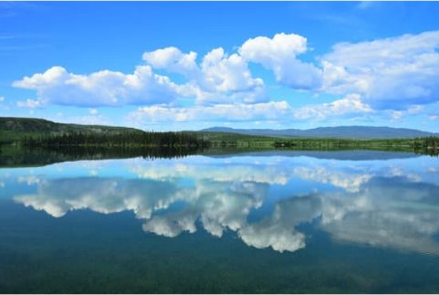 Photo of a landscape, water in foreground showing a mirror image of the land and sky above. Digital Twins mirror an organisation, process or system.